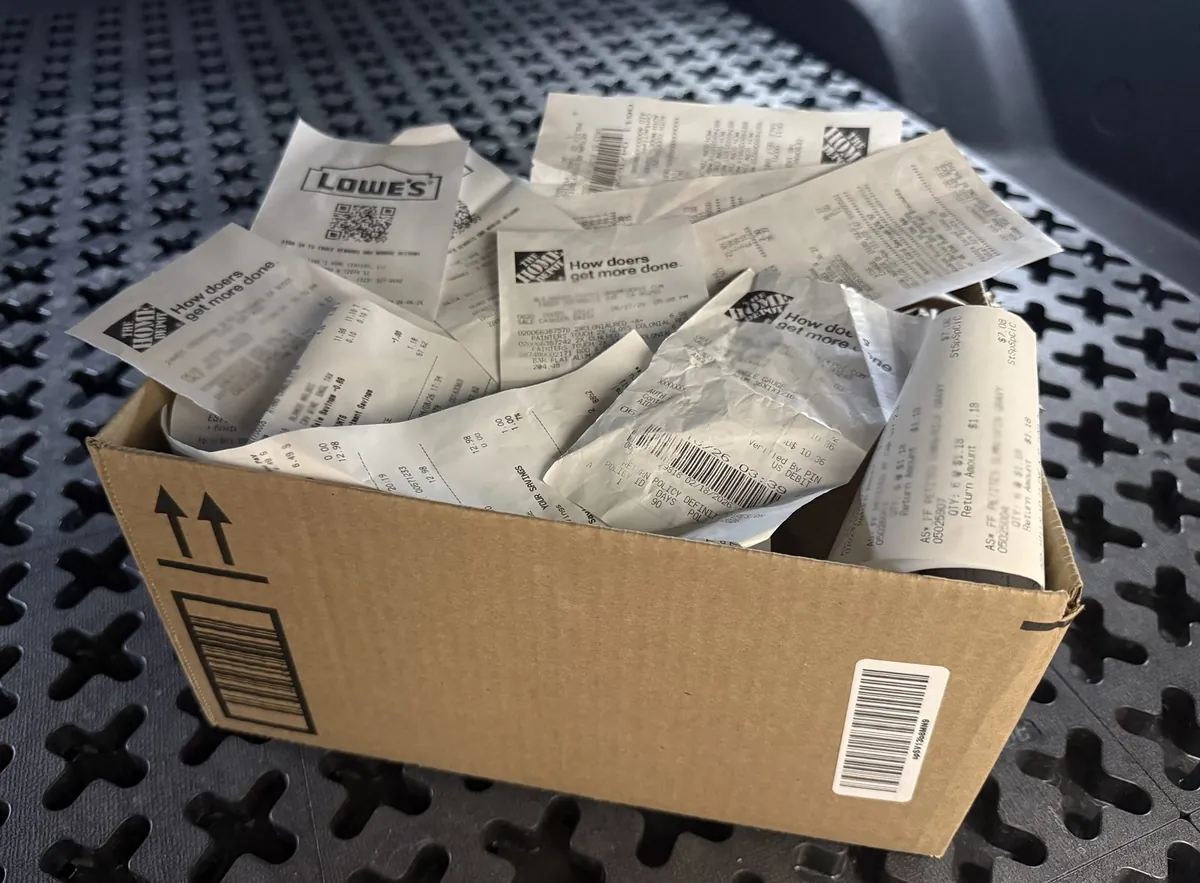 A shoebox stuffed with crumpled paper receipts
